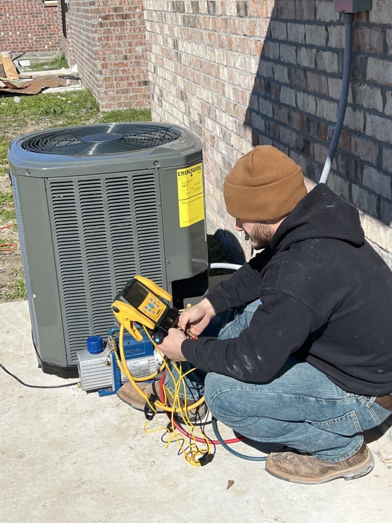technician performing ac maintenance on an outdoor ac unit